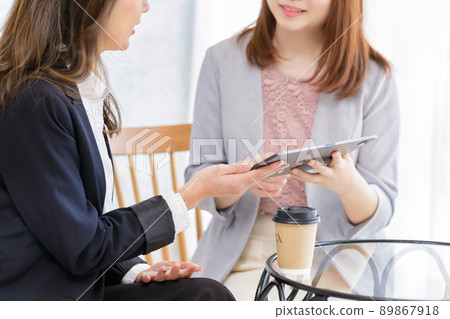 Two female colleagues looking at the tablet together 89867918