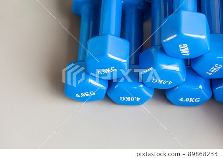 Athletic blue dumbbells folded on the gray floor. Studio shot Athletic blue dumbbells folded on the gray floor. Studio shot 89868233
