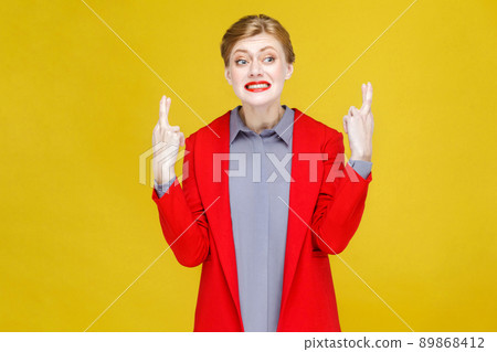 Pleese help! Ginger red head woman in red suit wish and dreaming, wish. Studio shot, isolated on yellow background Pleese help! Ginger red head woman in red suit wish and dreaming, wish. Studio shot, isolated on yellow background 89868412