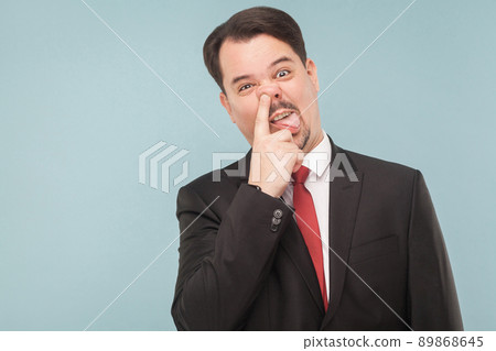 Has gone mad at work cause an ambulance he is not himself. indoor studio shot. isolated on light blue background. handsome businessman with black suit, red tie and mustache looking at camera. Has gone mad at work cause an ambulance he is not himself. indoor studio shot. isolated on light blue background. handsome businessman with black suit, red tie and mustache looking at camera. 89868645