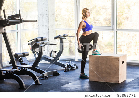 Woman with dumbbells doing cross fit exercise. Studio shot 89868771