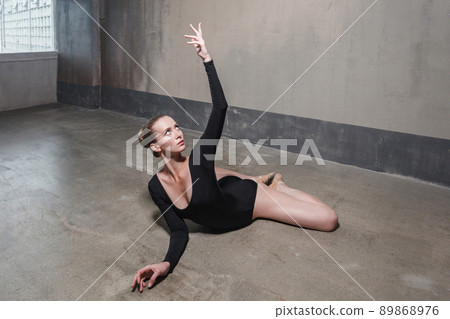 Instructor woman doing stretching. Studio shot, gray wall Instructor woman doing stretching. Studio shot, gray wall 89868976