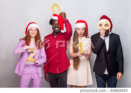 Happiness best friends showing number 2018 at camera. Studio shot, gray wall 89868985