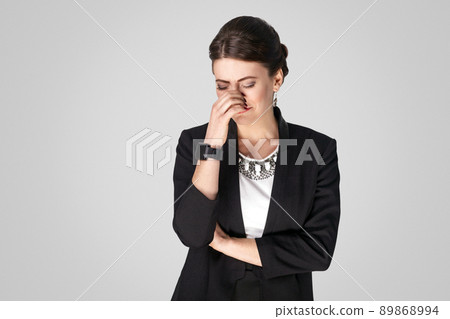 Well dressed woman in suit cry, have problem. Studio shot, indoor. Isolated on grey background Well dressed woman in suit cry, have problem. Studio shot, indoor. Isolated on grey background 89868994