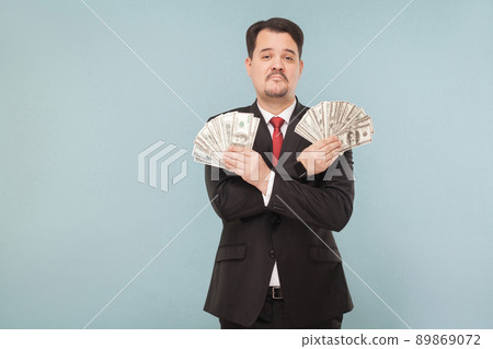 Portrait of cool wealthy successful businessman. Indoor, studio shot, isolated on light blue or gray background Portrait of cool wealthy successful businessman. Indoor, studio shot, isolated on light blue or gray background 89869072