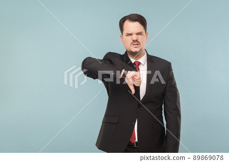 No, it's bad idea, realy. Business man showing dislike, fail sign. indoor studio shot. isolated on light blue background. handsome businessman with black suit, red tie and mustache looking at camera. No, it's bad idea, realy. Business man showing dislike, fail sign. indoor studio shot. isolated on light blue background. handsome businessman with black suit, red tie and mustache looking at camera. 89869078