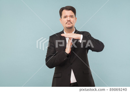 man needs more time. Working without productivity, the business falls. indoor studio shot. isolated on blue background. handsome businessman with black suit, red tie and mustache looking at camera. 89869240