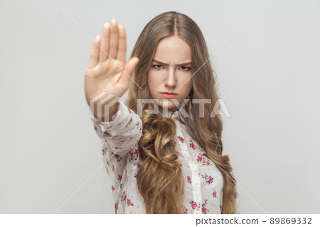 Stop! Rage young woman showing no sign. Studio shot, gray background Stop! Rage young woman showing no sign. Studio shot, gray background 89869332