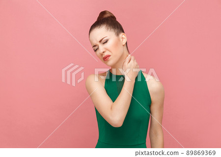 Woamn have neck pain. Expression emotion and feelings concept. Studio shot, isolated on pink background Woamn have neck pain. Expression emotion and feelings concept. Studio shot, isolated on pink background 89869369
