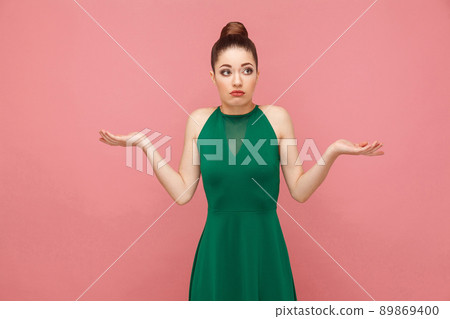 I don't know. Portrait of cute puzzled woman. Expression emotion and feelings concept. Studio shot, isolated on pink background 89869400