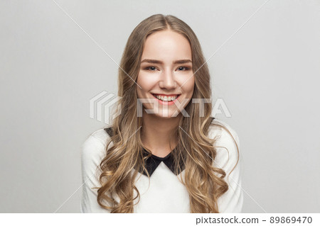 Businesswoman toothy smiling and looking at camera. Studio shot, gray background 89869470