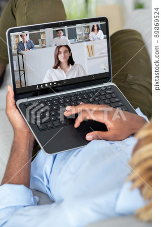 Web chat. Coworkers network. Internet interview. Relaxed employee working online discussing project with diverse business colleagues on laptop screen at home digital office. 89869524