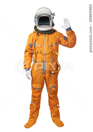 Astronaut wearing an orange spacesuit and helmet waives hand in hello gesture isolated over white background. Astronaut gesturing Hi greeting 89869960