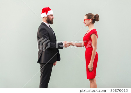 Handshake, celebrate good contract. Well dressed man and lady. Studio shot, gray background 89870013