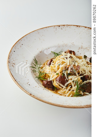 Fettuccine Pasta with Porcini Mushrooms in plate on white background 89870262