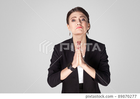Please help me. Woman apology and sorry. Studio shot, indoor. Isolated on grey background Please help me. Woman apology and sorry. Studio shot, indoor. Isolated on grey background 89870277