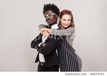 Happiness couple hugging and looking at camera. Indoor shot, gray background Happiness couple hugging and looking at camera. Indoor shot, gray background 89870401