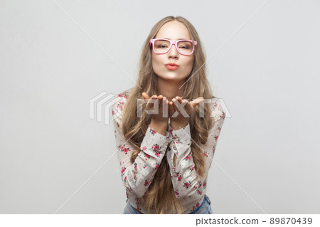 Blonde woman send air kiss at camera with love. Studio shot, isolated on gray background Blonde woman send air kiss at camera with love. Studio shot, isolated on gray background 89870439