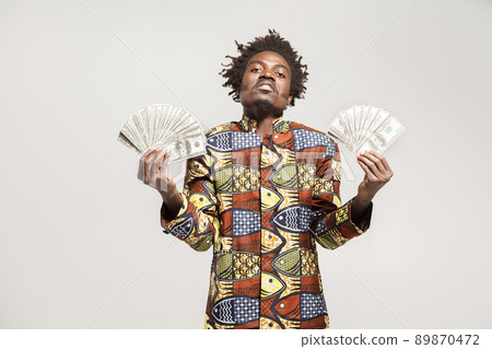 Success and richly african businessman or mafia boss. Indoor, isolated on gray background Success and richly african businessman or mafia boss. Indoor, isolated on gray background 89870472