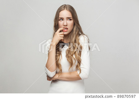 Hmm, let's my think. Confusion beautiful woman touching fingers her chin and wondering. Studio shot, gray background Hmm, let's my think. Confusion beautiful woman touching fingers her chin and wondering. Studio shot, gray background 89870597
