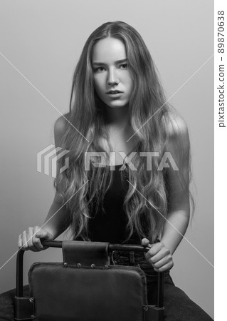 Retro picture. Actress with loose long hair, looking at camera. Studio shot, isolated on gray background 89870638