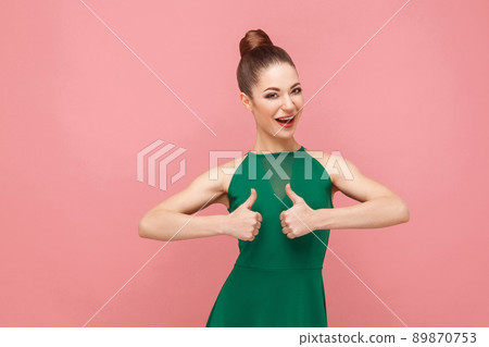 Cute woman showing like sign, thumbs up. Expression emotion and feelings concept. Studio shot, isolated on pink background Cute woman showing like sign, thumbs up. Expression emotion and feelings concept. Studio shot, isolated on pink background 89870753