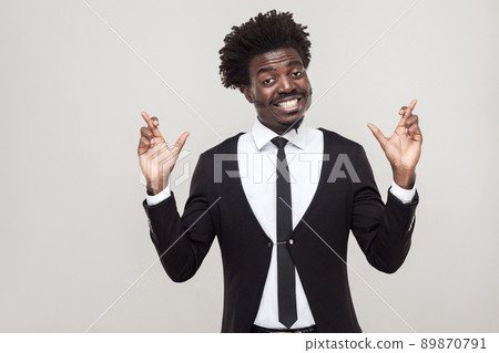 Happiness man wish and pray. Showing good luck sign. Studio shot, isolated on gray background Happiness man wish and pray. Showing good luck sign. Studio shot, isolated on gray background 89870791