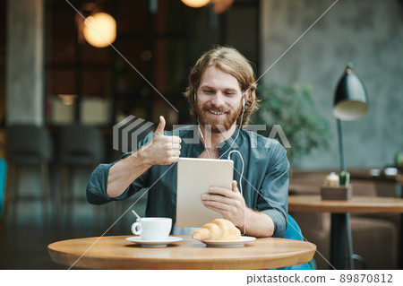 Above view of unrecognizable man taking photo of black coffee and croissant on table in cafe, bloggers lifestyle concept 89870812