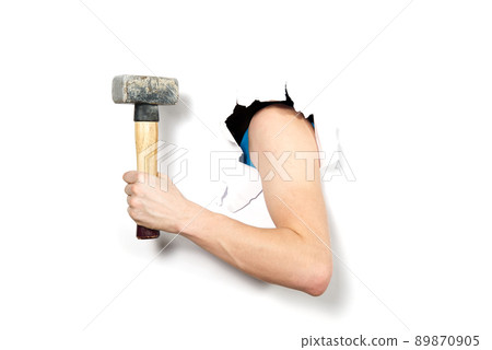 close-up hand with hammer through a torn white paper, isolated. hand holding Hammer close-up sledgehammer through hole in white paper. close-up hand with hammer through a torn white paper, isolated. hand holding Hammer close-up sledgehammer through hole in white paper. 89870905