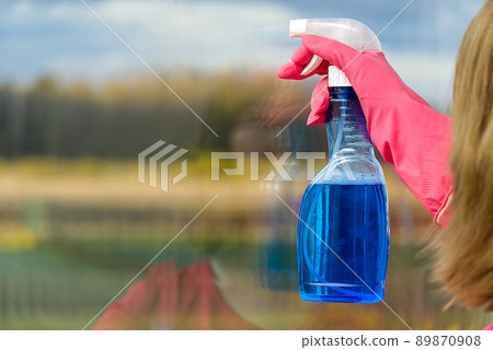 window cleaning. A woman in pink rubber gloves washes a window in a house. process of cleaning windows from dirt. window cleaning. A woman in pink rubber gloves washes a window in a house. process of cleaning windows from dirt. 89870908