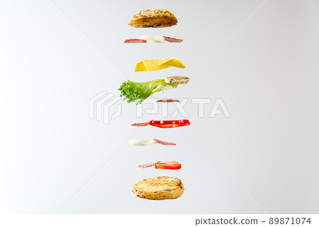 flying sandwich. Flying layers of sandwich. Well roasted patty, Ham, cheese and vegetables between two halves of an. American Breakfast food concept. flying sandwich. Flying layers of sandwich. Well roasted patty, Ham, cheese and vegetables between two halves of an. American Breakfast food concept. 89871074