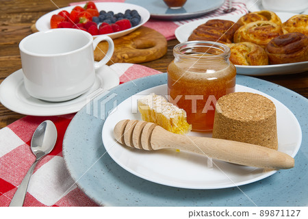 breakfast in the village fresh rolls, coffee, berries and honey laid out on an old brown wooden table. breakfast in the village fresh rolls, coffee, berries and honey laid out on an old brown wooden table. 89871127