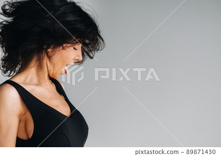 A woman in black sportswear is engaged in dynamic kali meditation in the Yoga hall 89871430