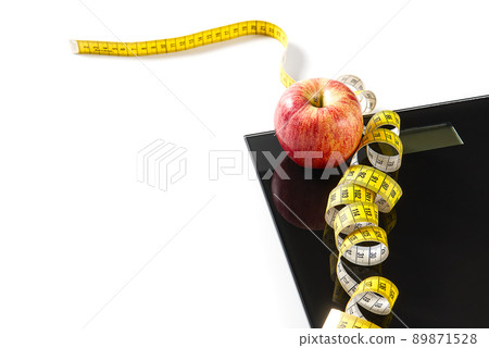 Diet plan, menu or program, tape measure, diet food of fresh fruits on white background, weight loss and detox concept, top view. weight loss concept. Apple and measuring tape. Diet. Diet plan, menu or program, tape measure, diet food of fresh fruits on white background, weight loss and detox concept, top view. weight loss concept. Apple and measuring tape. Diet. 89871528
