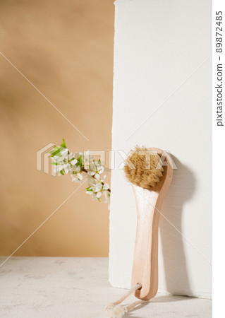 one small dry body brush on beige background. Set of home SPA cosmetic products. Women's organic skin care. Prevent cellulite and body problem at home one small dry body brush on beige background. Set of home SPA cosmetic products. Women's organic skin care. Prevent cellulite and body problem at home 89872485