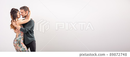 Skillful dancers performing in white background banner with copy space. Sensual couple performing an artistic and emotional contemporary dance bachata or kizomba or salsa Skillful dancers performing in white background banner with copy space. Sensual couple performing an artistic and emotional contemporary dance bachata or kizomba or salsa 89872748