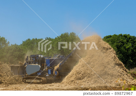 Construction site with work wood chipping machine the chipper process 89872967