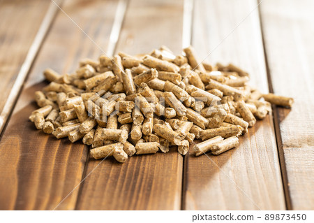 Wooden pellets, biofuel on wooden table. Ecologic fuel made from biomass. Renewable energy source. 89873450