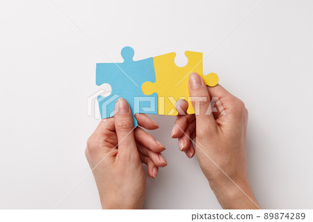 Ukrainian colors puzzle pieces in woman's hands 89874289