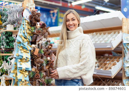 Christmas decoration shopping. Caucasian woman choose new year decor in shopping mall Christmas decoration shopping. Caucasian woman choose new year decor in shopping mall 89874601