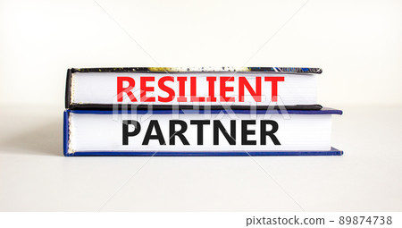 Resilient partner symbol. Concept words Resilient partner on books on a beautiful white table white background. Business resilience and resilient partner concept, copy space. Resilient partner symbol. Concept words Resilient partner on books on a beautiful white table white background. Business resilience and resilient partner concept, copy space. 89874738