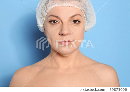 Mature woman with double chin on blue background Mature woman with double chin on blue background 89875006