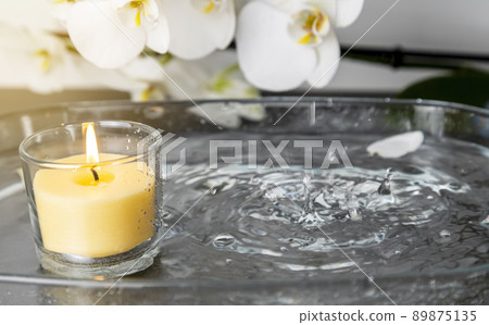 Photo of a candle with rain, drops of water extinguishing the fire, splashes of water 89875135