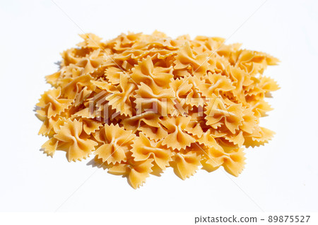 Uncooked bow tie pasta on white background. Uncooked bow tie pasta on white background. 89875527