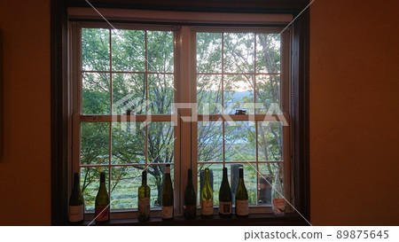Evening view outside the window through the wine bottle Evening view outside the window through the wine bottle 89875645