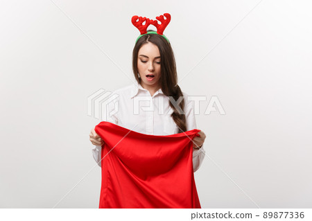 Christmas Concept - Young beautiful business woman surprise with present in santa bag. Christmas Concept - Young beautiful business woman surprise with present in santa bag. 89877336