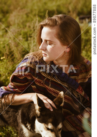 close-up. Profile of a beautiful girl with natural beauty sitting among the grass in a hug with a dog close-up. Profile of a beautiful girl with natural beauty sitting among the grass in a hug with a dog 89877888