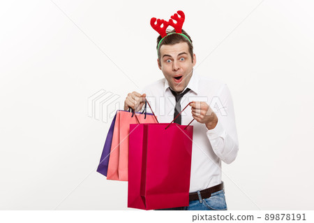 Christmas Concept - Handsome Business man celebrate merry christmas and happy new year wear reindeer hairband and holding Santa red big bag. Christmas Concept - Handsome Business man celebrate merry christmas and happy new year wear reindeer hairband and holding Santa red big bag. 89878191