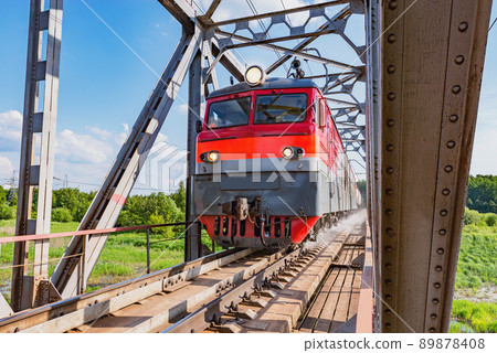 Long freight train approaches to the station. 89878408