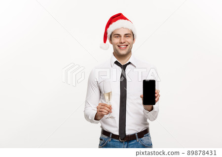 Christmas Concept - Handsome Business man talking on phone and holding glass of champange celebrating Chirstmas and New year. 89878431